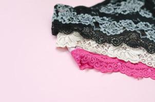 White, black and pink women underwear with lace on pink background with copy space. Advertising for shop of beautiful and comfortable women underwear photo