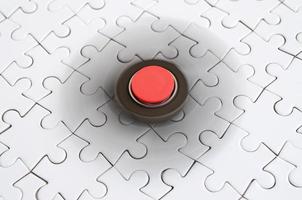 A wooden spinner spins on a white jigsaw puzzle background photo