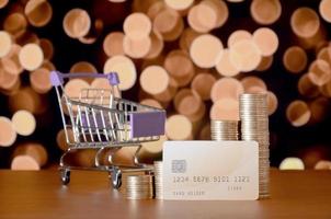 Empty shopping cart and money stacks in growth graph at the beige credit card photo