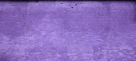 The texture of the brick wall of many rows of bricks painted in violet color photo