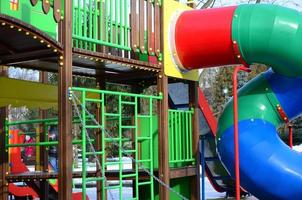 Fragment of a playground made of plastic and wood, painted in different colors photo