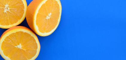Top view of a several orange fruit slices on bright background in blue color. A saturated citrus texture image photo