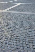 Fragment of the street square, folded out of a gray square paving stone photo