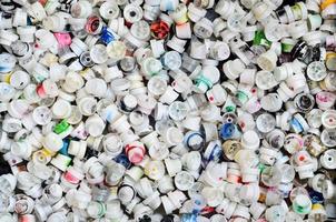 A pattern of many used and soiled nozzles from spray cans with aerosol paint. Background texture of the street art of drawing graffiti on the walls photo