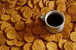 taza de café pequeña y galleta salada foto