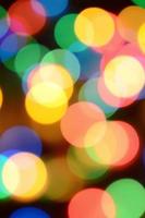 Blurred festive colorful lights over black useful as background. All main colors included. Red, yellow, green and blue photo