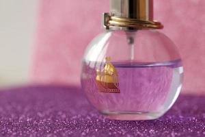 TERNOPIL, UKRAINE - SEPTEMBER 2, 2022 Lanvin Eclat Darpege perfume bottle on shiny glitter background in purple colors photo