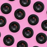 A few camera lenses with a closed aperture lie on texture background of fashion pastel pink color paper in minimal concept. Abstract trendy pattern photo