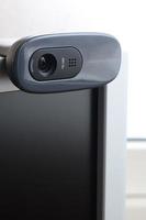 A modern web camera is installed on the body of a flat screen monitor. Device for video communication and recording of high quality video photo