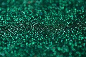 A huge amount of green decorative sequins. Background image with shiny bokeh lights from small elements photo