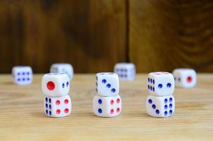 A few dice lies on the surface of natural wood. Items for generating numbers from one to six in the form of points that are painted on the side of cubes. The concept of gambling photo