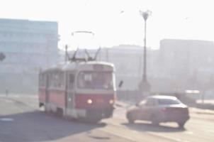 Blurred landscape of highway with cars and tram in foggy morning photo