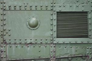 The texture of the wall of the tank, made of metal and reinforced with a multitude of bolts and rivets. Images of the covering of a combat vehicle from the Second World War photo