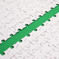 The green path is laid on the platform of a white folded jigsaw puzzle. Texture image with copy space for text photo