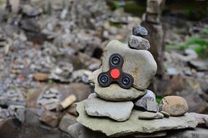 A wooden spinner lies on strange stone structures in the forest photo