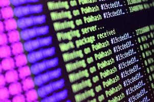 Macro snapshot of the program interface for crypto currency mining on the monitor of an office computer. The concept of mining bitcoins. The flow of information strings and data photo