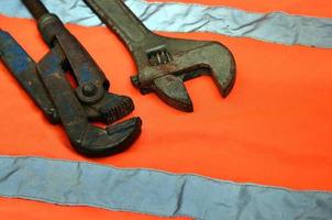 Adjustable and pipe wrenches against the background of an orange photo