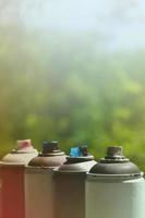 A few used aerosol paint sprayers lie on the windowsill in the workshop of a graffiti artist. The concept of street art and illegal drawing on the walls. Youth hobby photo