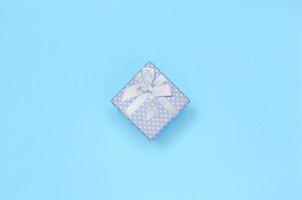 pequeña caja de regalo azul se encuentra en el fondo de textura de papel de color azul pastel de moda foto