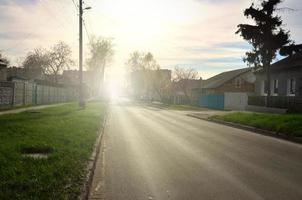 Asphalt road in the middle of a rural landscape in the early summer photo