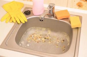 Close up on dirty clogging kitchen sink drain with food particles photo