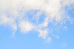 A blue cloudy sky with many small clouds blocking the sun photo