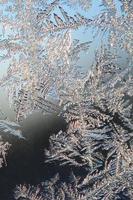 Snowflakes frost rime macro on window glass pane photo