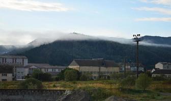 The apartment building is in front of a thick layer of fog. Living in a mountainous area in the Carpathians, Ukraine photo