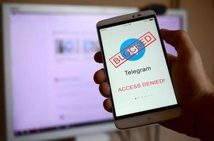 KHARKOV, UKRAINE - APRIL 30, 2018 A mobile phone with the Telegram app screen with a prohibiting sign. Roskomnadzor blocked the Telegram service in Russia. Access to telegram messenger is closed photo