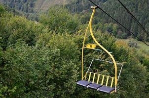 The seats of the cable car on the background of Mount Makovitsa, one of the Carpathian Mountains photo