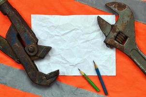 Adjustable wrenches and a sheet of paper with two pencils photo