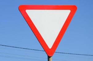 Traffic sign in the form of a white triangle. Give way photo