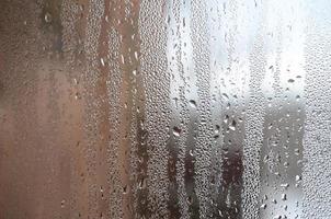 The texture of a misted glass with a lot of drops and condensation flows. Background image photo