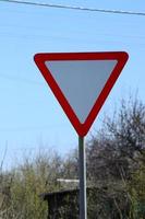 Traffic sign in the form of a white triangle. Give way photo
