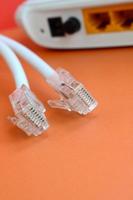 Internet router and Internet cable plugs lie on a bright orange background. Items required for Internet connection photo