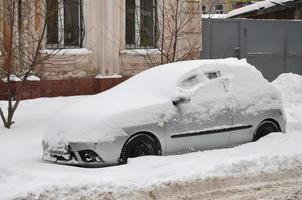 kharkov, ucrania - 4 de diciembre de 2016 un automóvil estacionado bajo una gruesa capa de nieve. consecuencias de una fuerte e inesperada nevada en ucrania foto