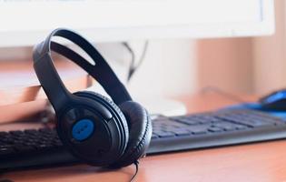 Big black headphones lie on the wooden desktop of the sound designer photo