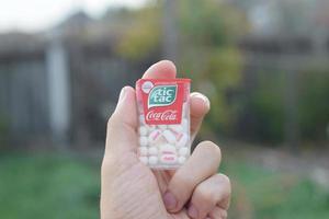 KHARKOV. UKRAINE - MAY 2, 2019 Tic Tac Candy package with Coca-Cola taste in male hand. Tic tac is popular due its minty fresh taste and easy to carry. Hard mints produced by Ferrero since 1968 photo