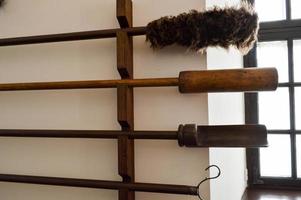 Large long wooden sticks, shampols with fluffy brushes for cleaning old antique cannons photo