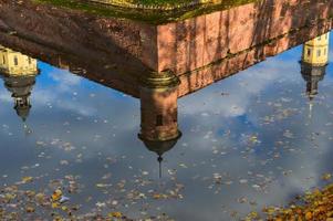 Reflection in the water of an old, ancient medieval castle in the center of Europe with towers and spiers. The background photo