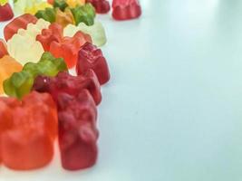 voluminous, bright gelatinous gummy bears. bears lie on a matte background. volumetric figure. bears of heterogeneous different structure. delicious and mouth-watering creative dessert photo