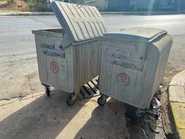 Large iron shiny metal containers for garbage and waste on wheels. Recycling, collection and disposal of garbage photo