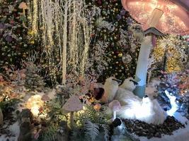 Decoraciones de navidad. un oso polar de juguete se encuentra debajo de un hongo colorido y mueve sus patas. junto a ella hay setas de colores. lindos juguetes de nochebuena para niños foto