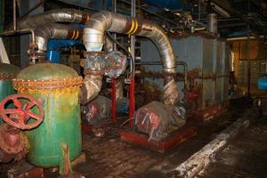 Viejo hierro de metal oxidado abandonado mal en equipo de corrosión intercambiadores de calor bombas de tuberías en un taller de planta petroquímica química de refinería industrial foto