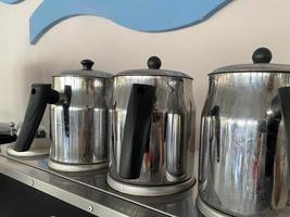 Shiny metal chrome teapots for brewing hot tasty tea photo