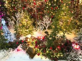 christmas decoration. cute decor for showcase. deer made of luminous garlands. next to him is a fox, a raccoon and other animals. new year in the forest photo