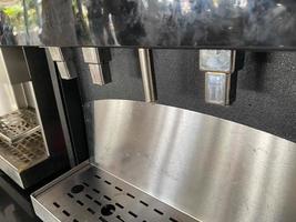 Shiny metal taps and tubes for pouring coffee from a coffee machine. Apparatus for hot drinks photo