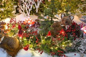 camachuelo y bayas decoración de juguete en las ramas de un árbol de navidad foto