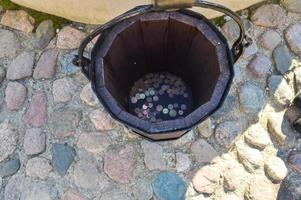 Large round wooden bucket with coins photo