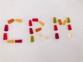 word from gummy gummy bears. edible letters C, R, M. vitamin word. English alphabet. delicious appetizing dessert. bright bears on a white matte background photo